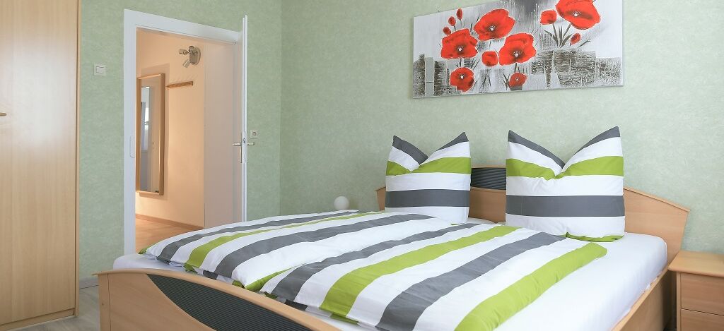 Innenaufnahme Zimmer mit Doppelbett und Kleiderschrank