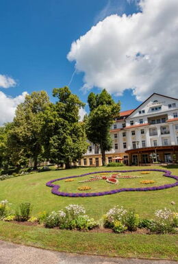 Landschaftsaufnahme Historischer Kurpark mit Bepflanzung, Wandelhalle und Kulturhotel Kaiserhof