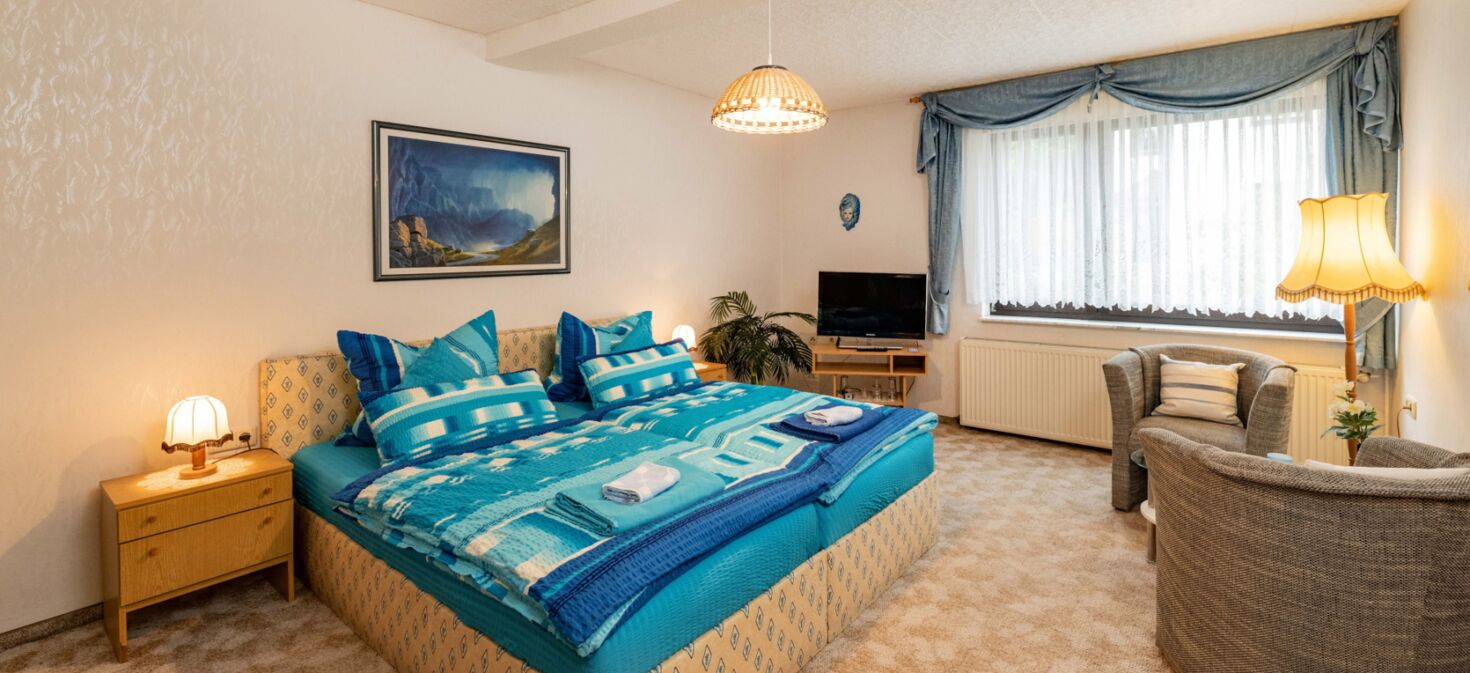 Innenaufnahme Zimmer mit Doppelbett und Sesseln