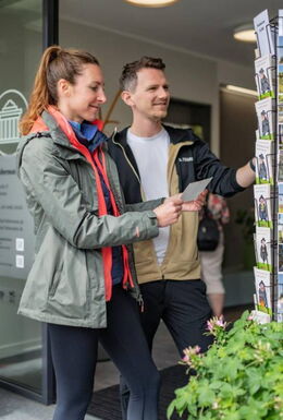 Eingangsbereich der Tourist-Informationen mit Pflanzkübeln und Postkartenständer