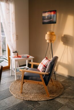 Innenaufnahme mit Sitzecke, Sessel und Blick auf Balkon