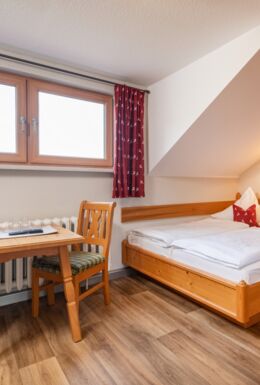 Innenaufnahme Zimmer mit Doppelbett und Sitzbereich