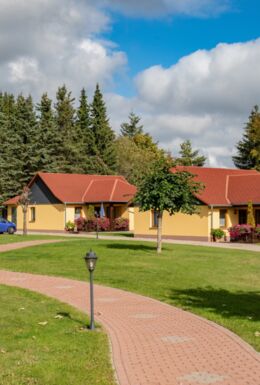 Außenaufnahme Bungalows mit Garten und Sitzbänken